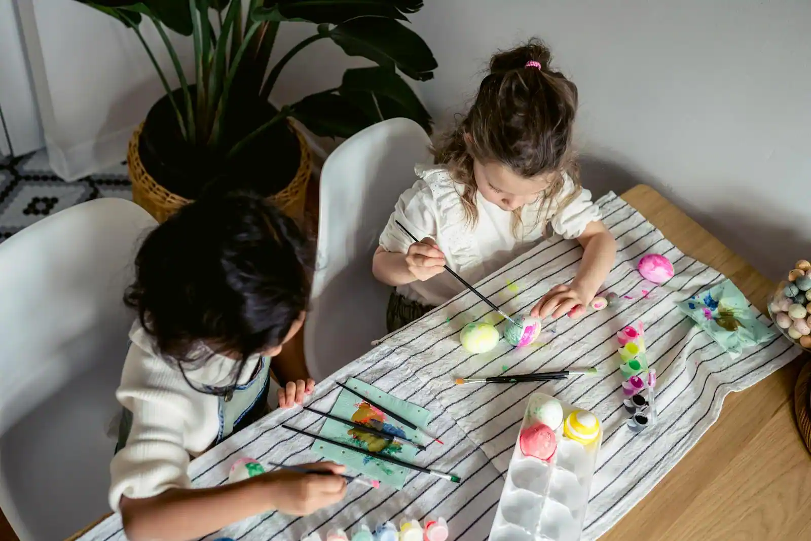 Table d'activités manuelles de Pâques avec œufs colorés, peinture et fournitures créatives