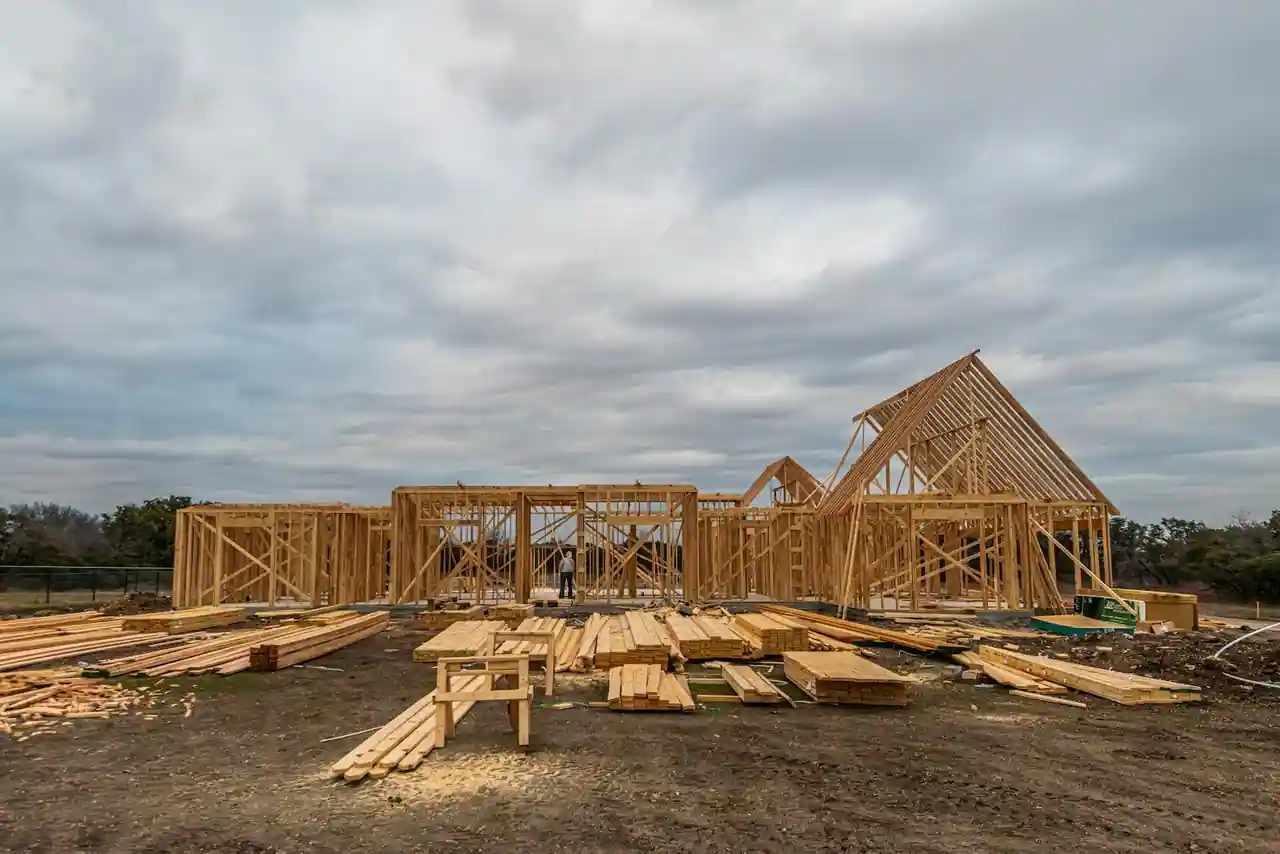 Maison individuelle à ossature bois avec bardage en mélèze, baies vitrées et toiture moderne sous une lumière du matin