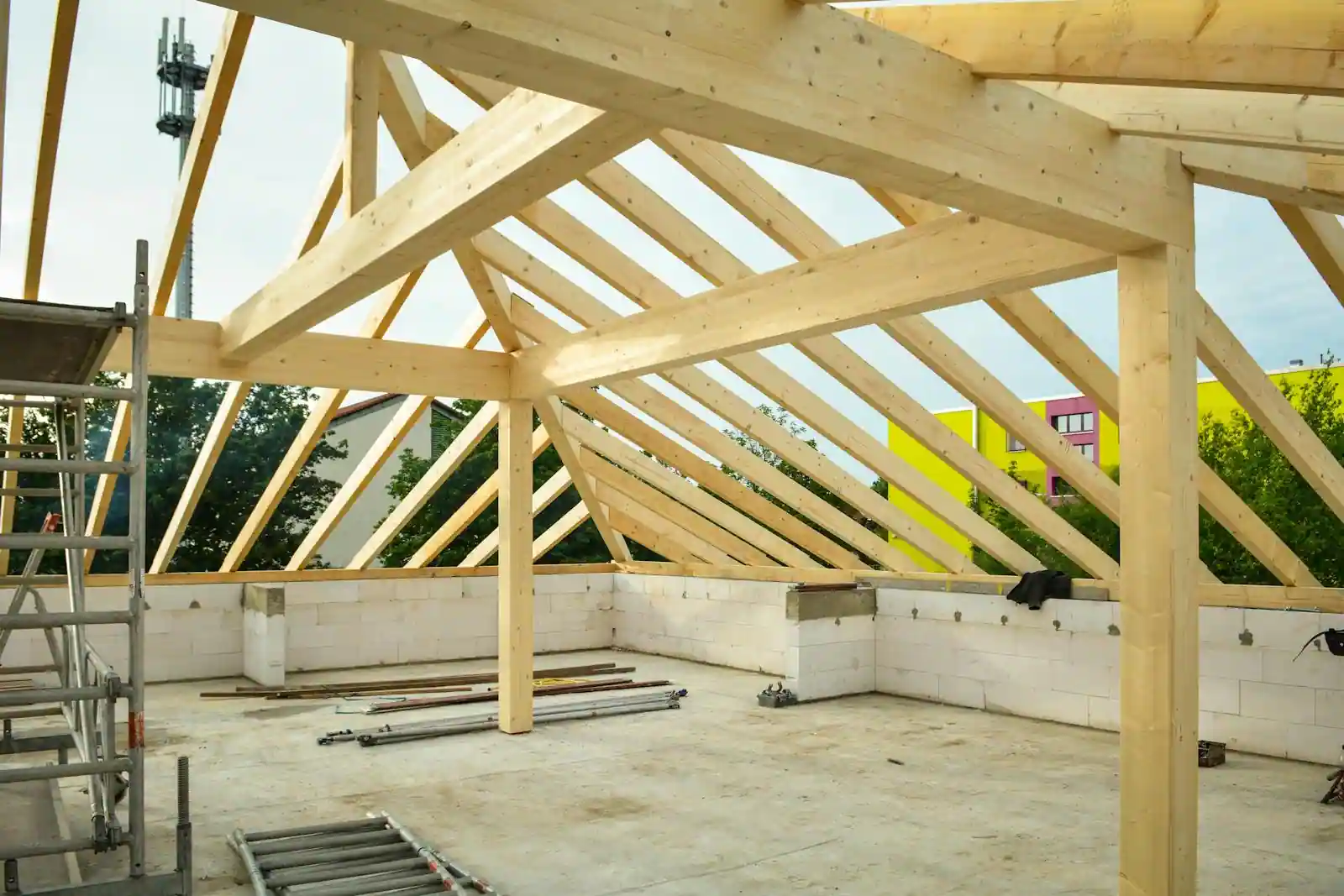 Maison individuelle neuve en construction avec ossature visible et grue de chantier