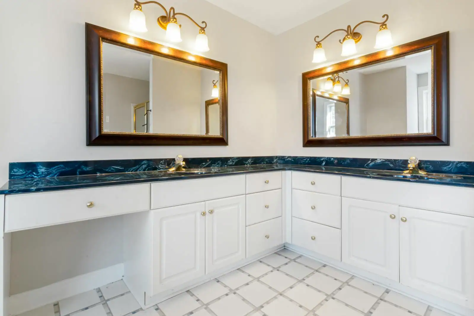 Salle de bain contemporaine avec meuble sous lavabo blanc à tiroirs, miroir et colonne assortie, sous lumière naturelle
