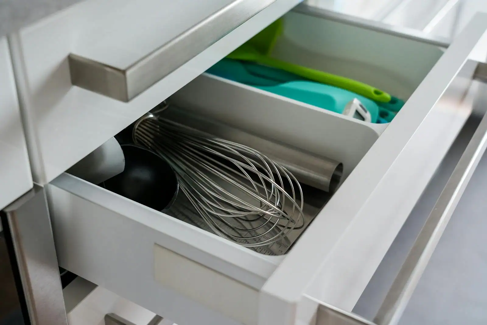 Tiroirs coulissants ouverts dans une cuisine moderne montrant un rangement organisé