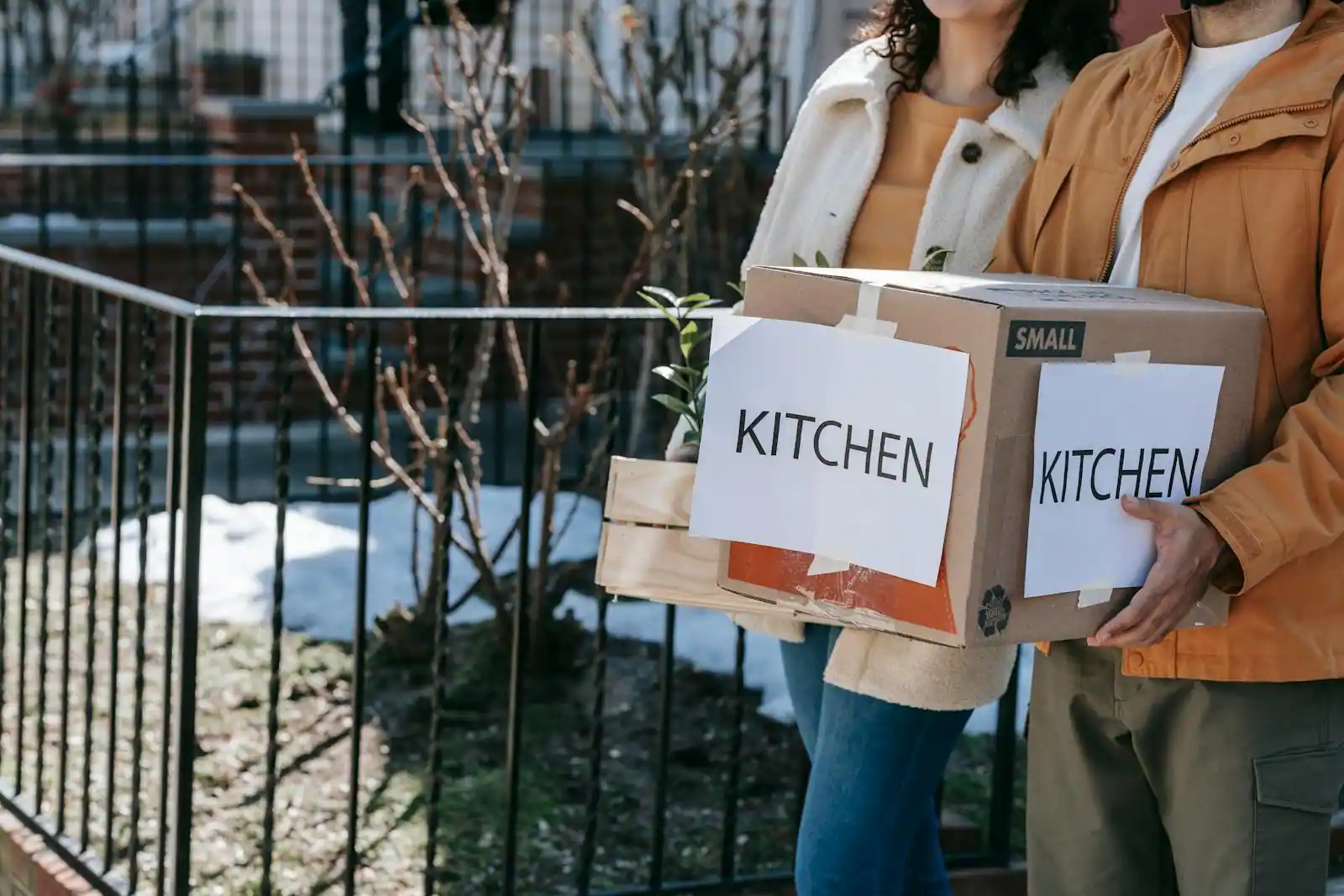 Réfrigérateur combiné blanc dans une cuisine d'emménagement avec étiquette énergétique visible, plan de travail clair et carton ouvert à côté