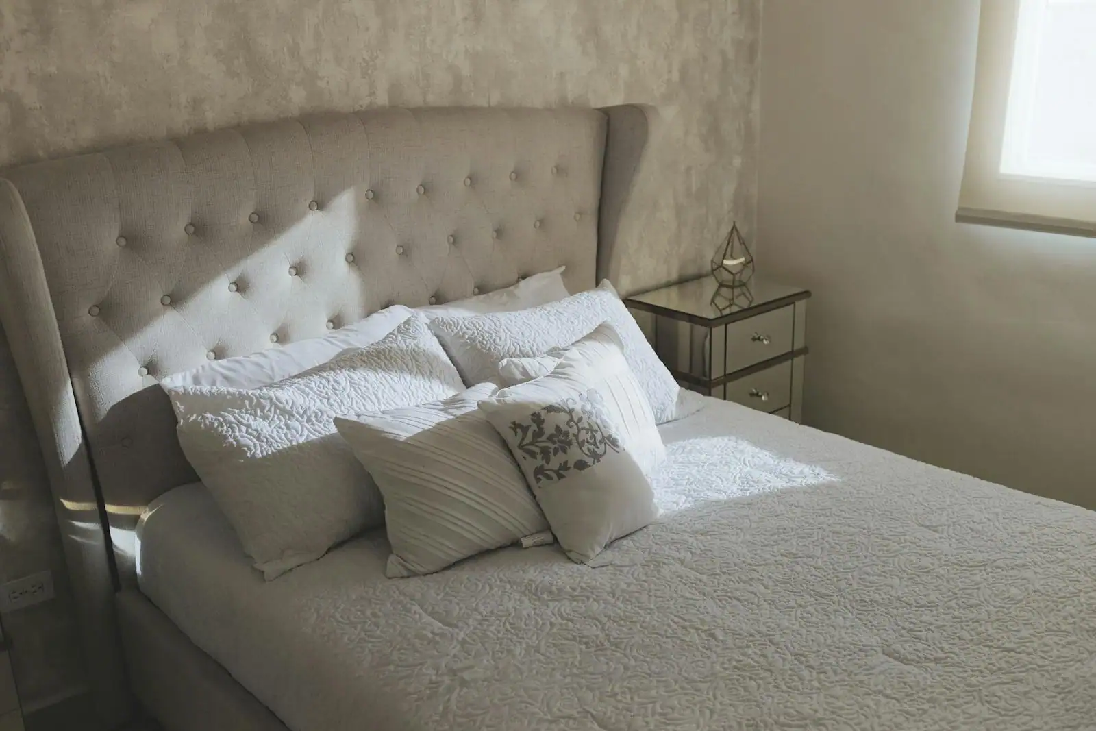 Chambre d'adulte sereine, lit à tête capitonnée et linge clair dans une palette apaisante.