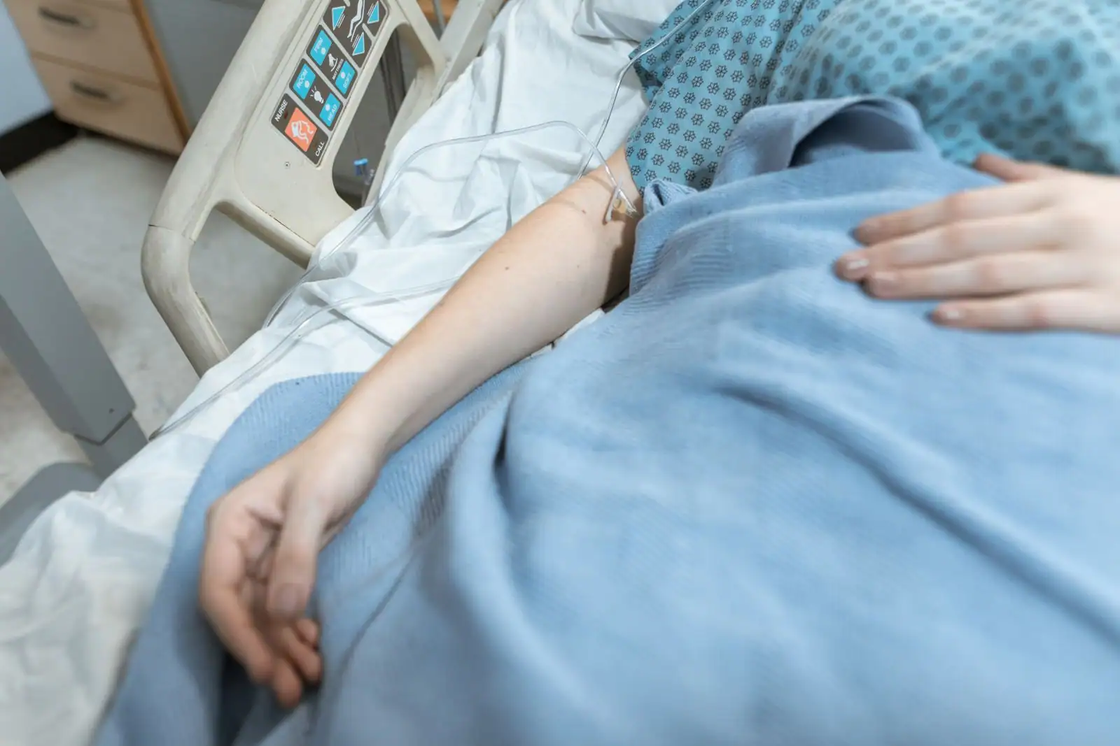 Perfusion intraveineuse installée au bras d'un patient dans un service hospitalier