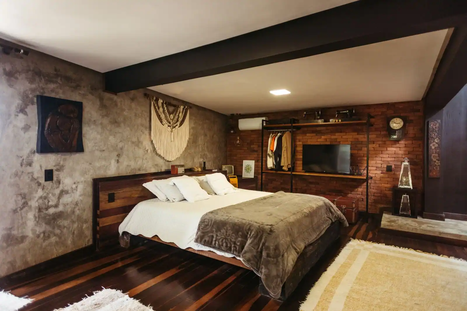 Chambre chaleureuse avec un mur de briques apparentes et du bois, illustrant une déco aux tons rouges doux.