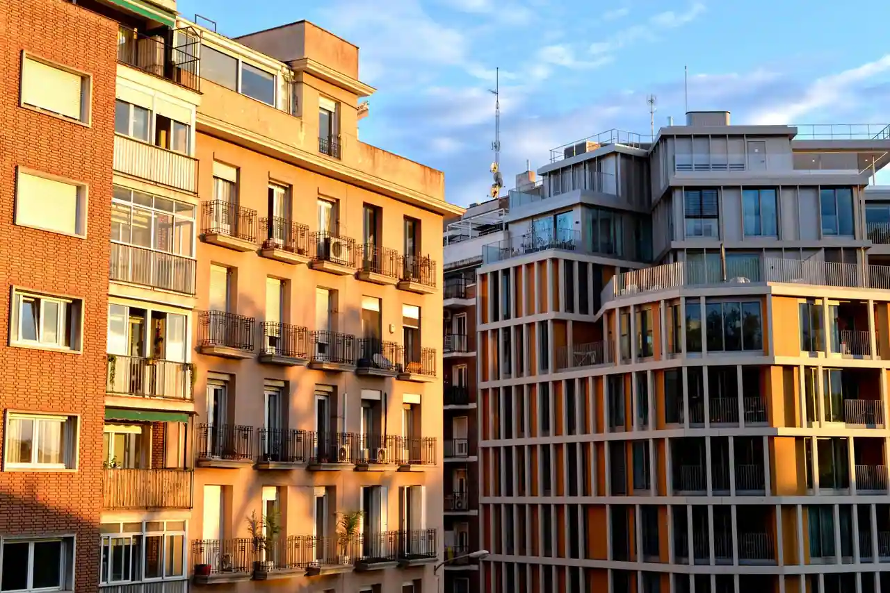 Façades d'immeubles résidentiels en ville au coucher du soleil, bâtiments anciens et modernes côte à côte