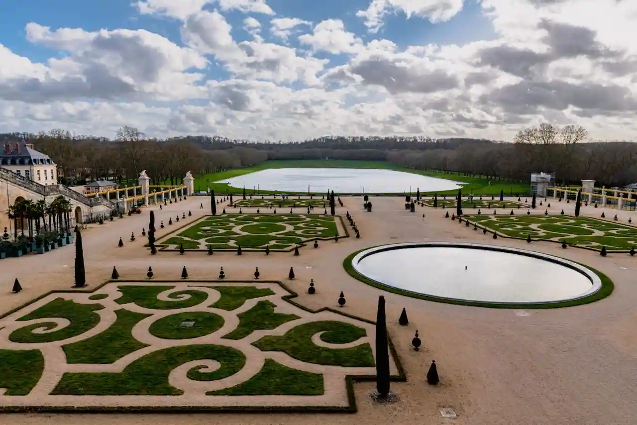 Jardins à la française du château de Versailles : parterres brodés, topiaires et bassins ornementaux.