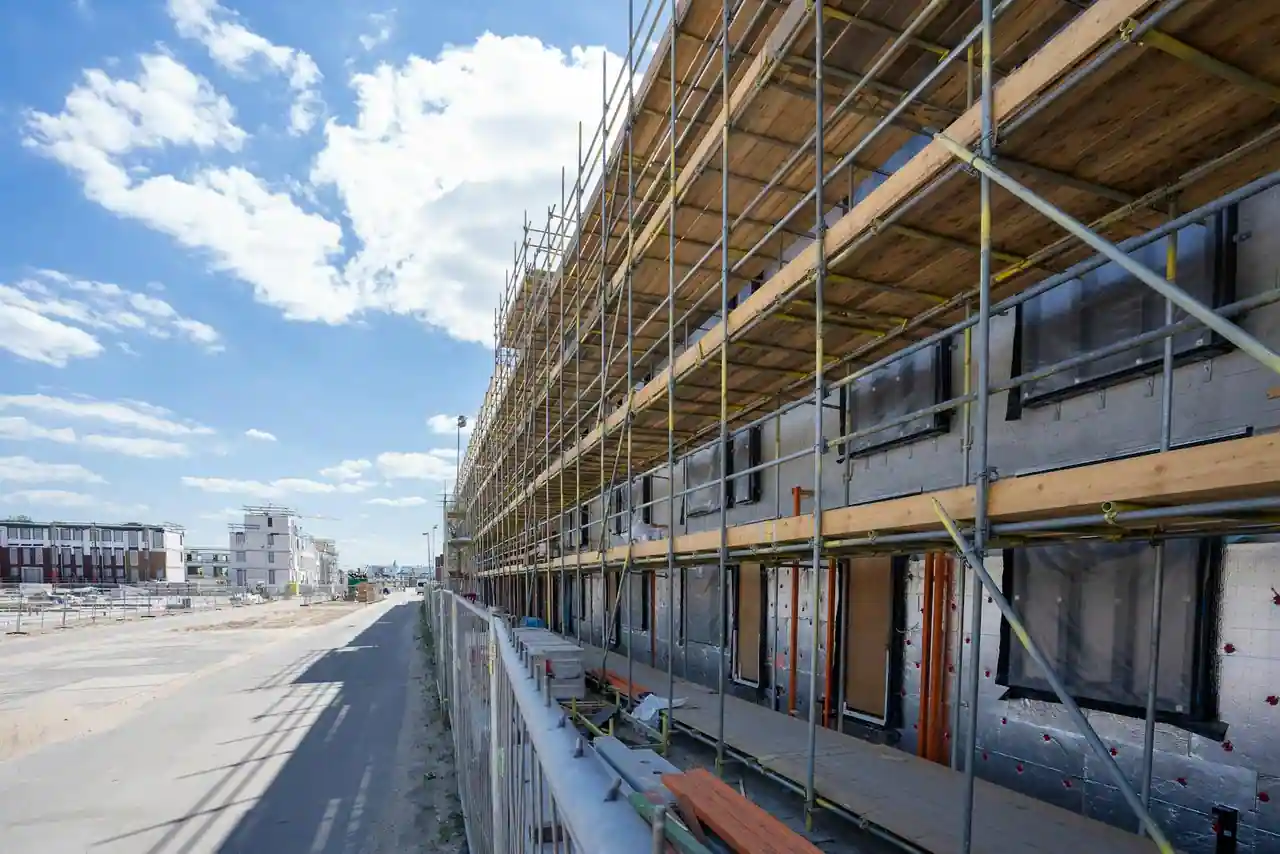 Bâtiment en construction couvert d'échafaudages sur un chantier neuf, par temps ensoleillé