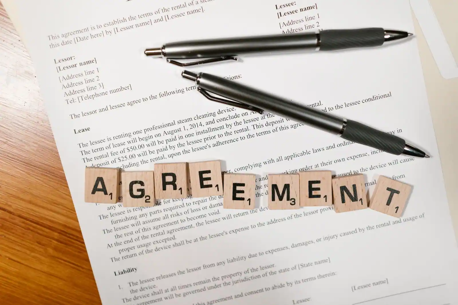 Contrat de location et stylos posés sur une table, évoquant la signature d'un bail entre particuliers.