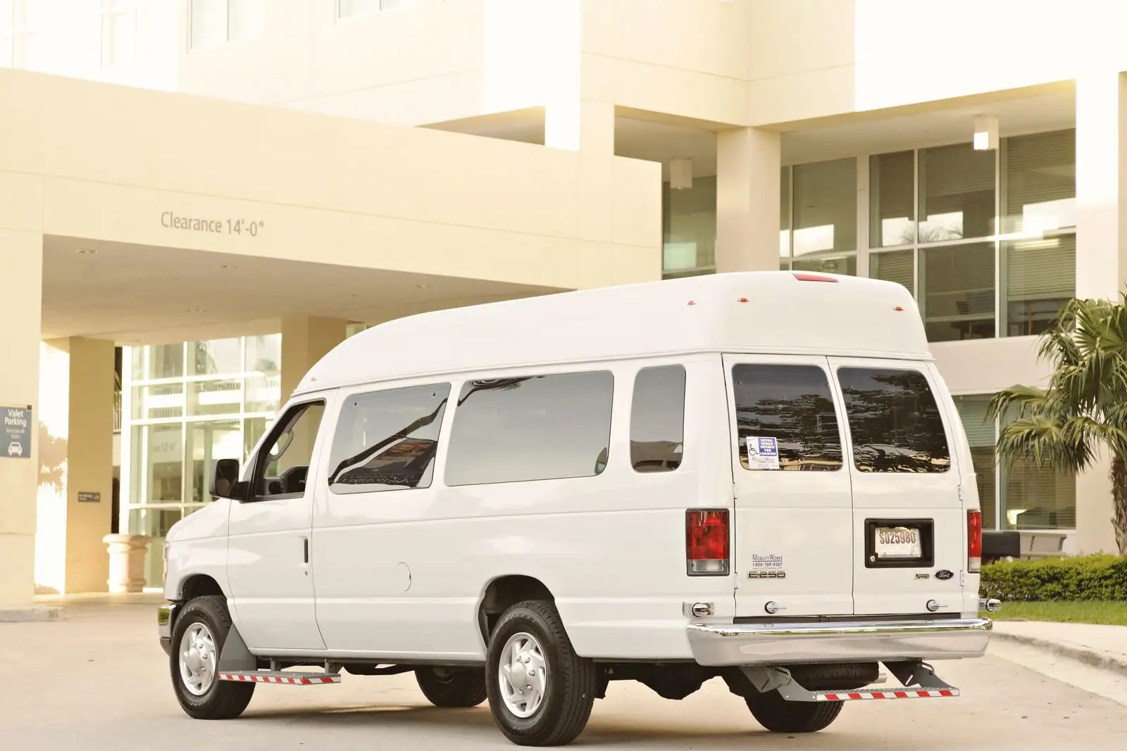 Minibus blanc stationné à l'extérieur devant un bâtiment, véhicule de transport de groupe