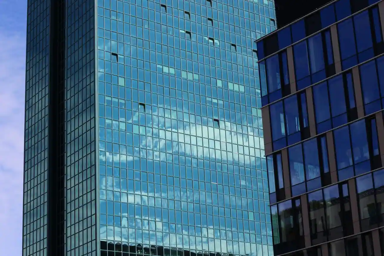 Façade vitrée d'un immeuble de bureaux moderne en centre d'affaires, évoquant l'univers des entreprises accompagnées par une chambre de commerce et d'industrie.