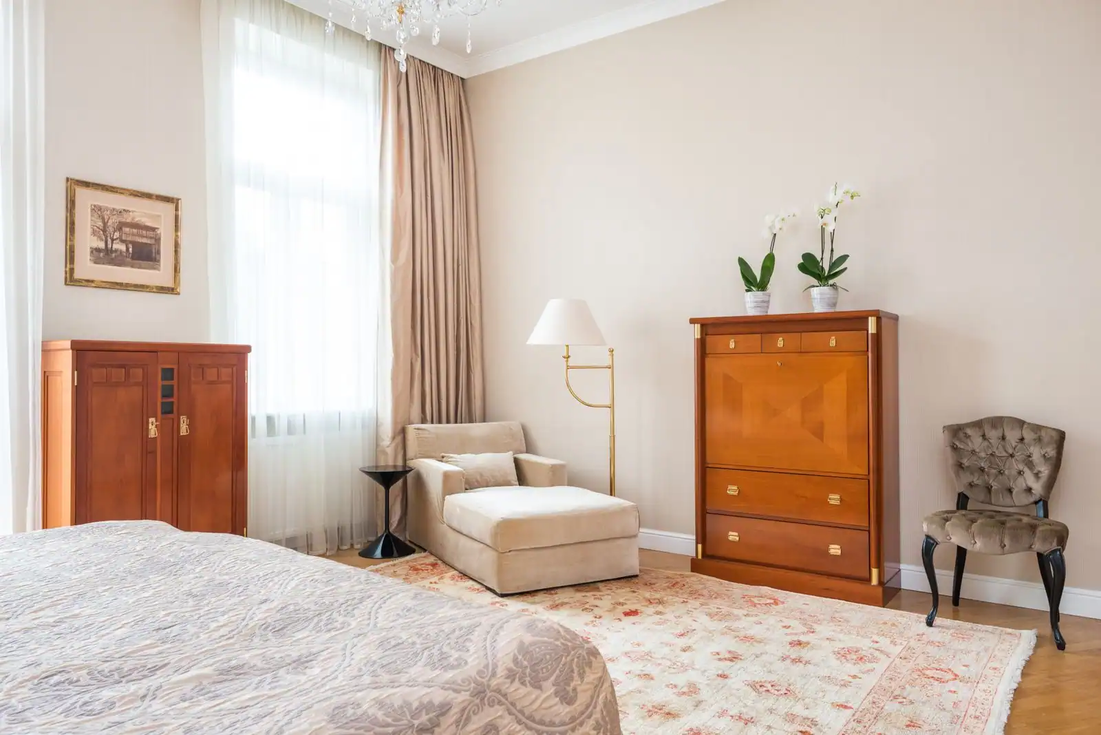 Chambre à coucher élégante avec lit, commode et armoire en bois clair, méridienne et fenêtre à rideaux.