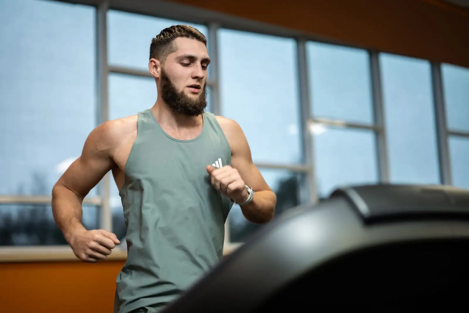 Athlète à l'effort sur tapis de course dans une salle d'entraînement, préparation physique en hypoxie