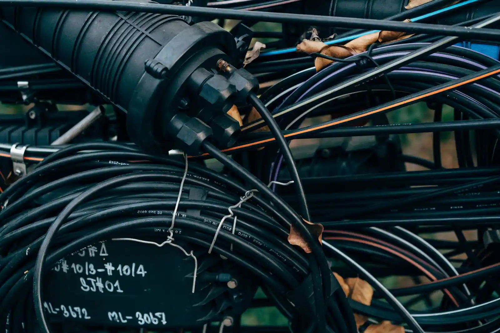 Câbles à fibre optique lovés autour d’un manchon de raccordement télécom, contenu typique d’une chambre de tirage.
