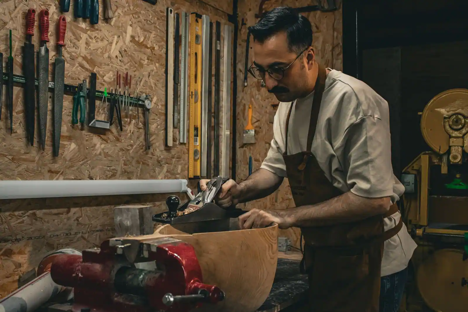 Artisan menuisier au travail dans son atelier avec ses outils