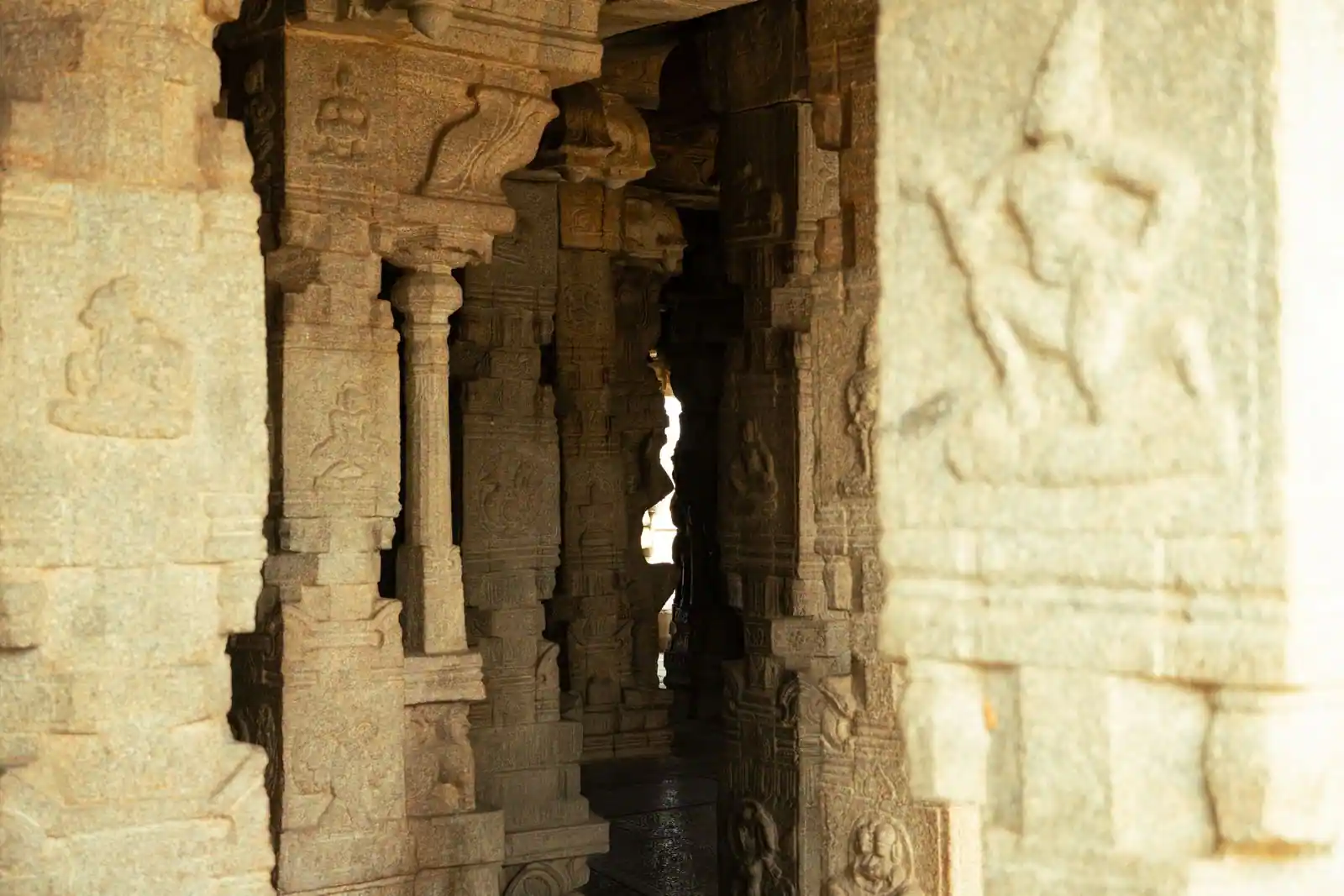Chambre souterraine en pierre aux parois gravées de symboles anciens, évoquant un lieu d'énigme