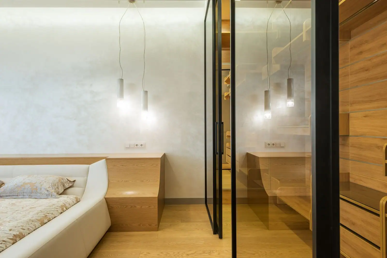 Chambre aux murs clairs éclairée par une porte vitrée et des lampes d'appoint