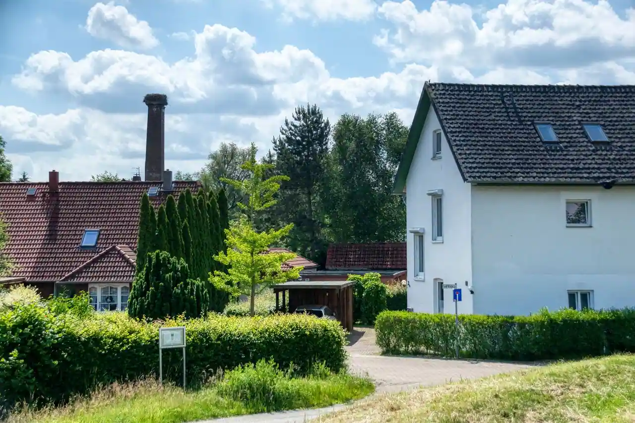 Maisons résidentielles voisines séparées par des haies et une clôture basse en limite de propriété