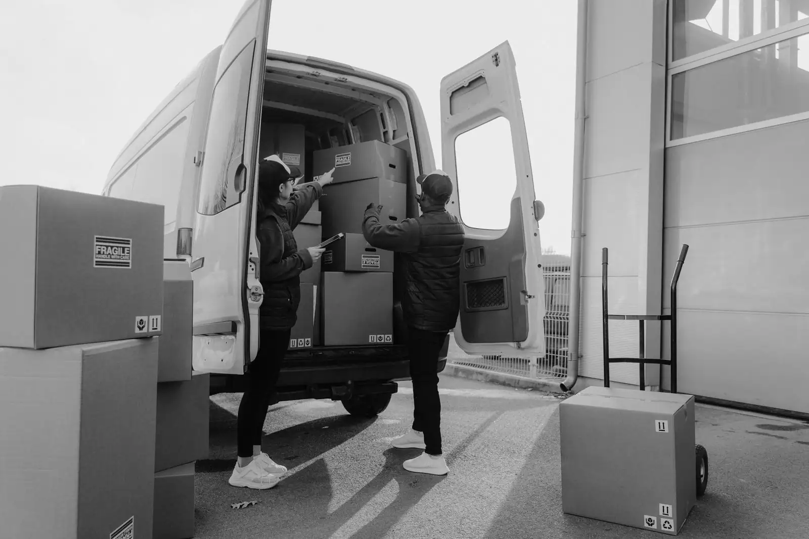 Des personnes chargent des cartons de déménagement dans un camion utilitaire.