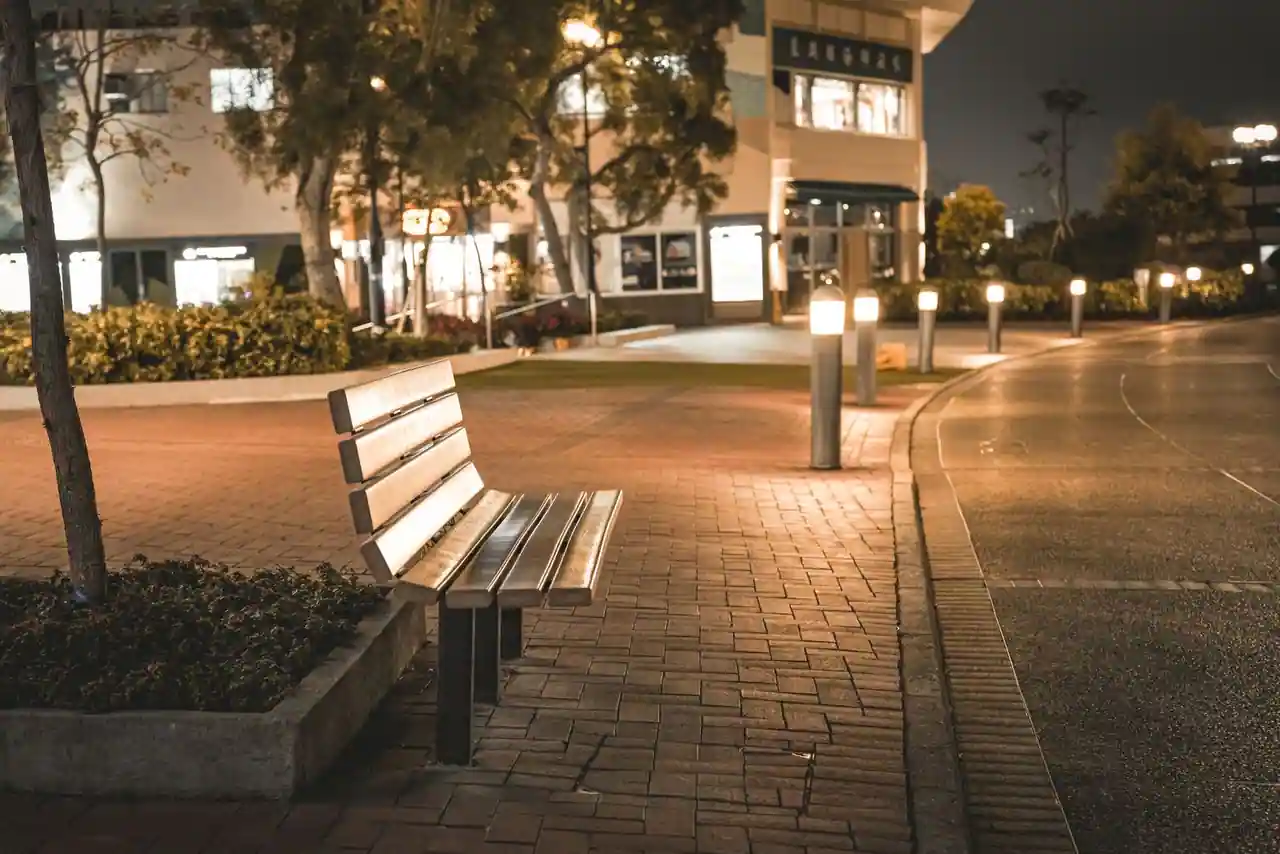 Banc public et lampadaire sur une place pavée en ville