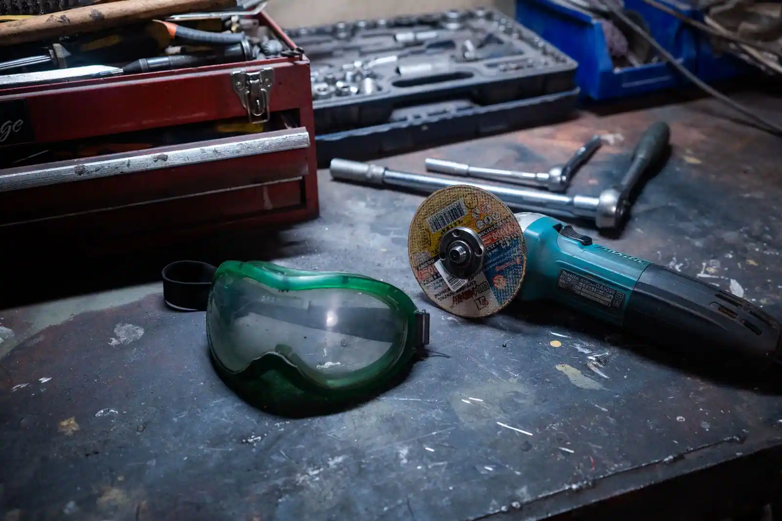 Établi d'atelier avec des outils électroportatifs et manuels posés côte à côte