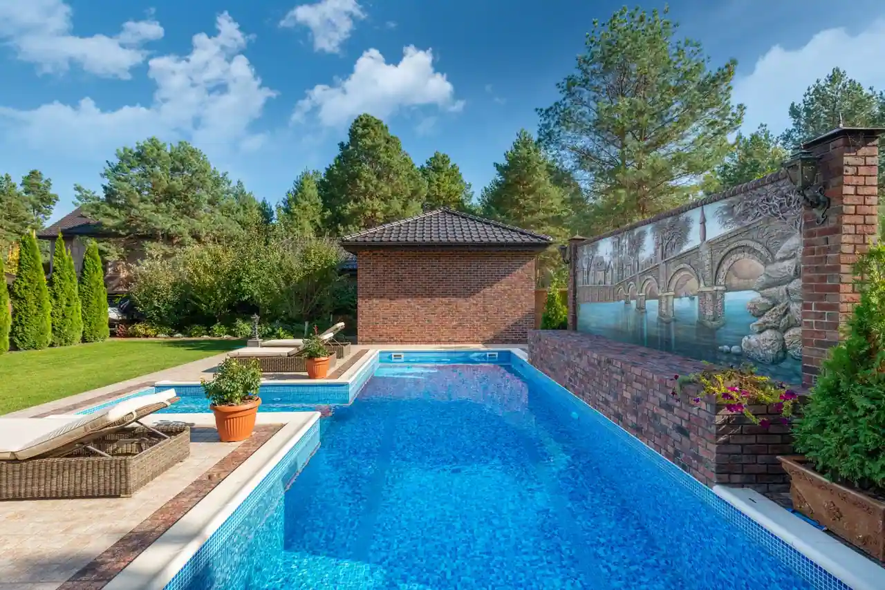 Piscine extérieure propre avec eau claire et margelles, dans un jardin ensoleillé