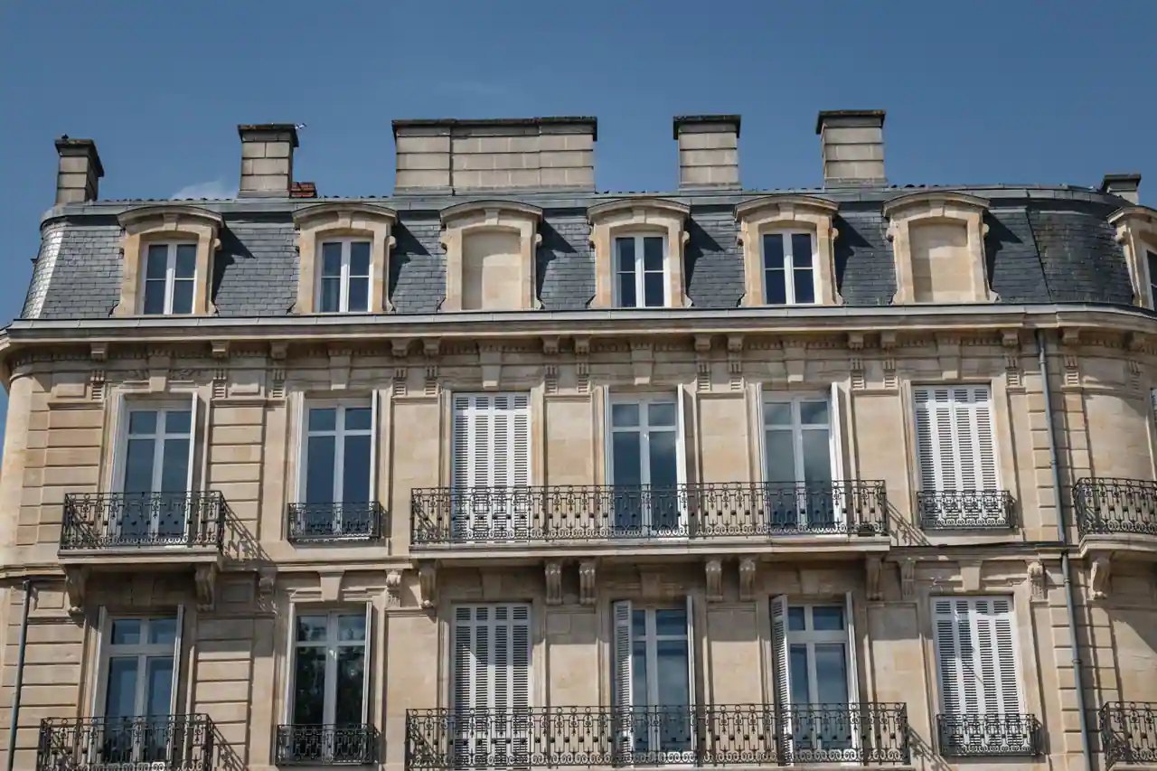 Façade en pierre blonde d'un immeuble d'habitation bordelais, balcons en fer forgé et hautes fenêtres