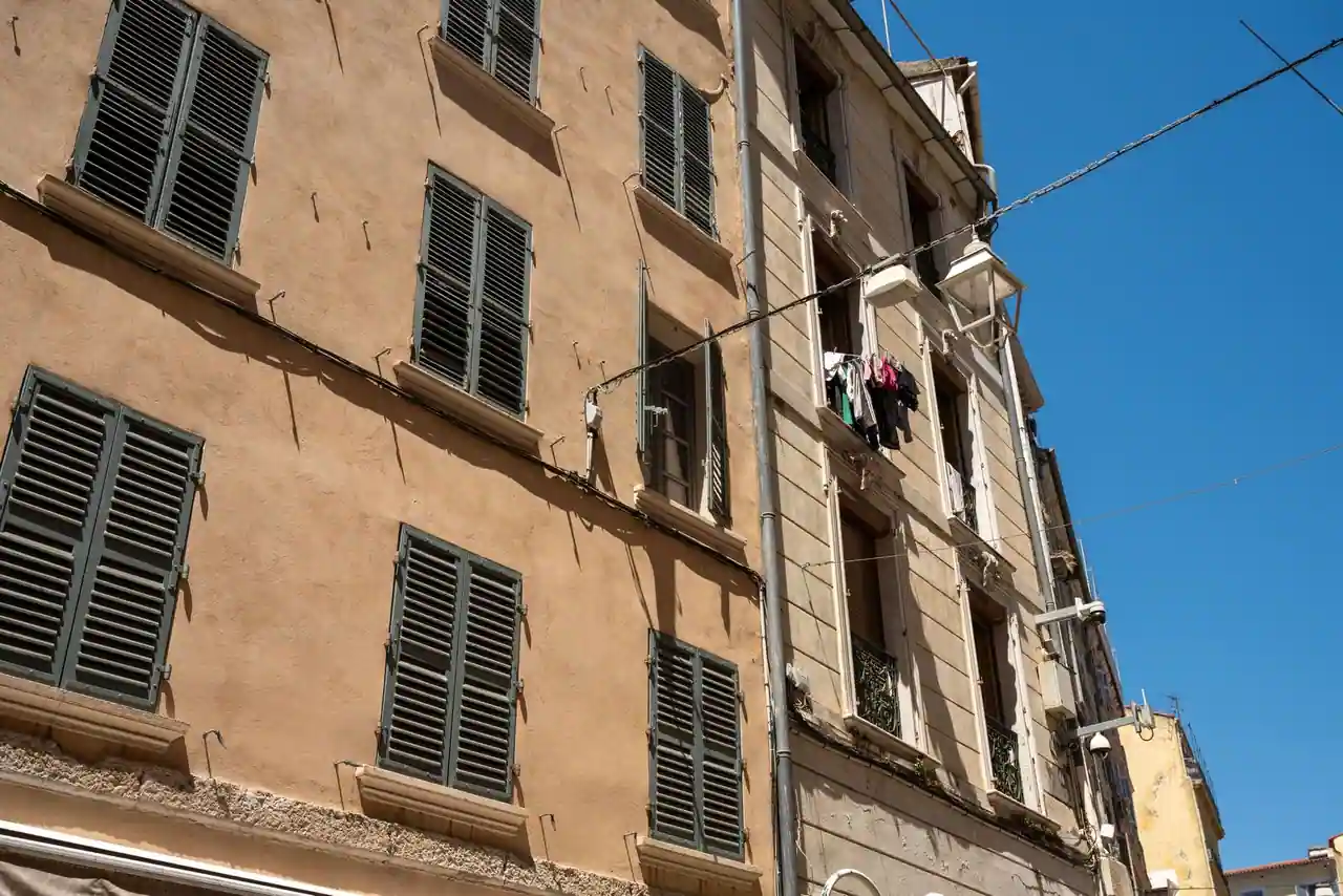 Façades ocre aux volets provençaux dans une rue du centre ancien de Toulon, linge aux fenêtres.